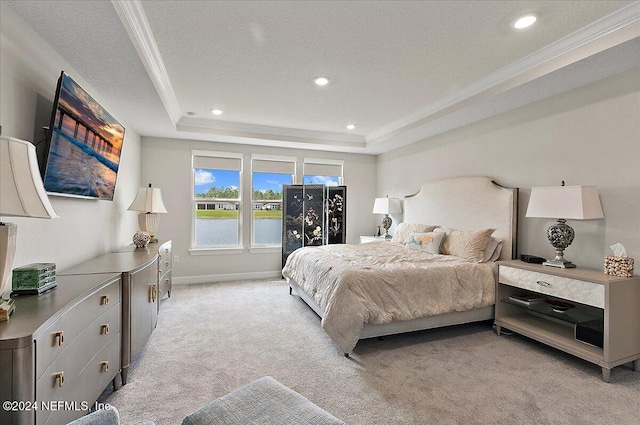 carpeted bedroom featuring ornamental molding, a textured ceiling, and a tray ceiling