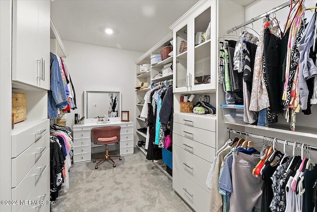 walk in closet featuring light colored carpet