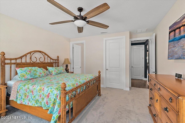 carpeted bedroom with ceiling fan and a textured ceiling