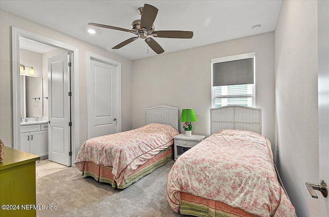 carpeted bedroom featuring ceiling fan, sink, and ensuite bathroom