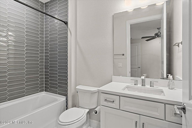 full bathroom featuring vanity, tiled shower / bath combo, toilet, and ceiling fan