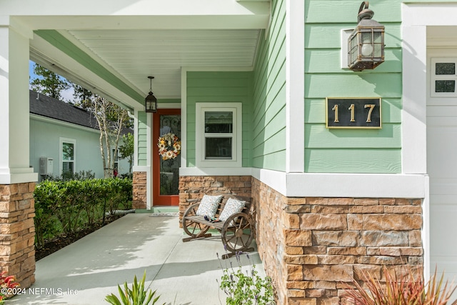 view of exterior entry with a porch