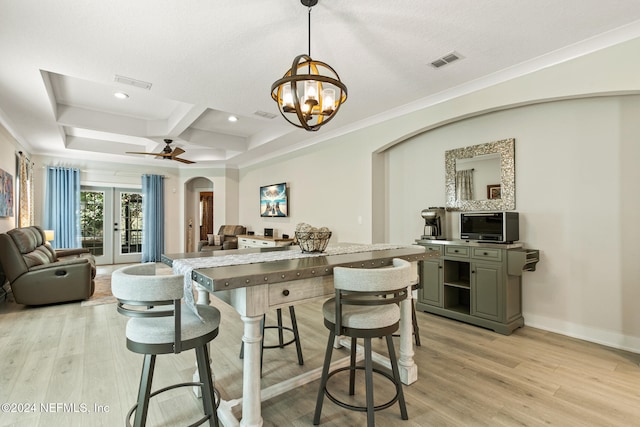 kitchen featuring french doors, coffered ceiling, ceiling fan with notable chandelier, pendant lighting, and light hardwood / wood-style floors