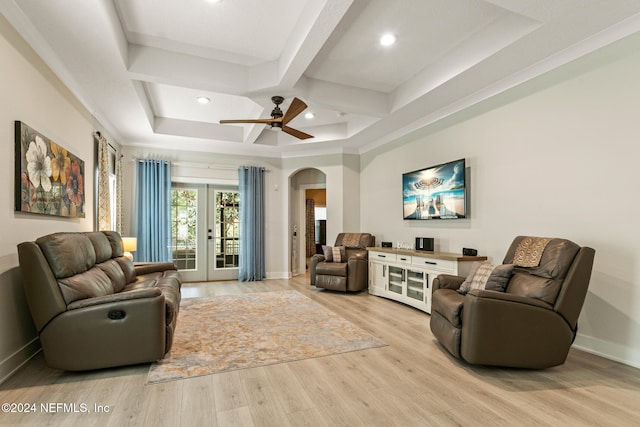 living room with french doors, a tray ceiling, light hardwood / wood-style flooring, and ceiling fan