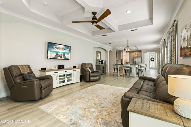 living room with hardwood / wood-style floors, coffered ceiling, ceiling fan with notable chandelier, crown molding, and beamed ceiling