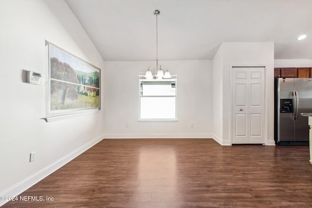 unfurnished dining area featuring dark hardwood / wood-style flooring, lofted ceiling, and an inviting chandelier