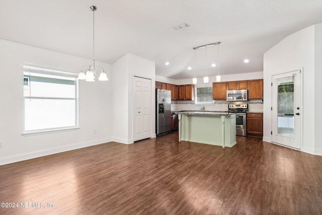 kitchen featuring appliances with stainless steel finishes, decorative light fixtures, a chandelier, dark hardwood / wood-style floors, and a kitchen island