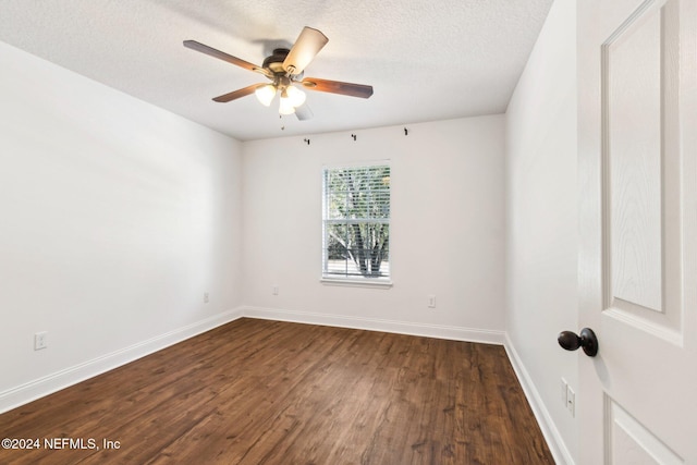 empty room featuring ceiling fan, dark hardwood / wood-style flooring, and a textured ceiling