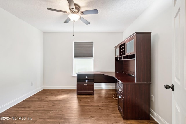 unfurnished office with a textured ceiling, ceiling fan, and dark wood-type flooring