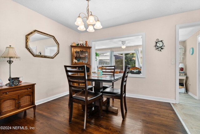 dining area with ceiling fan with notable chandelier and dark hardwood / wood-style flooring