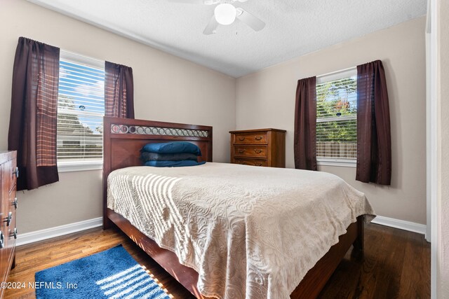 bedroom featuring multiple windows, ceiling fan, hardwood / wood-style floors, and a textured ceiling