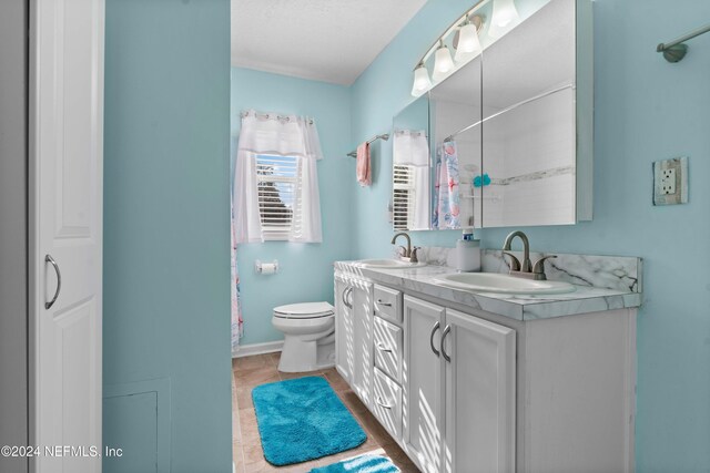 bathroom featuring vanity, toilet, and walk in shower