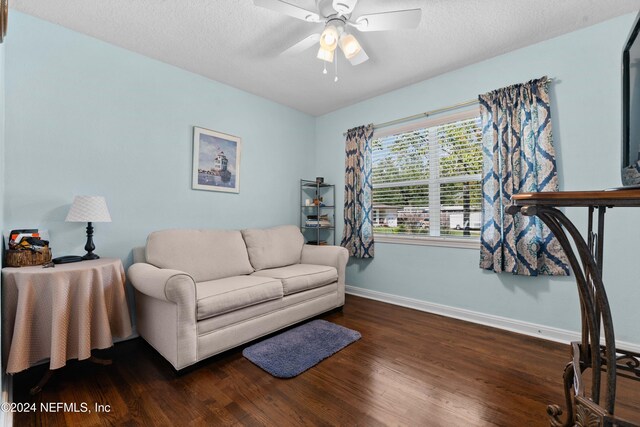 living room featuring a textured ceiling, dark hardwood / wood-style flooring, and ceiling fan