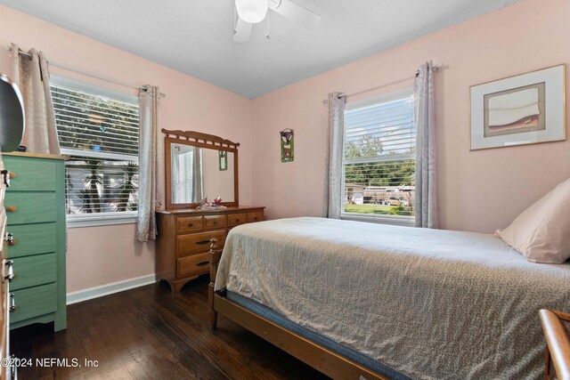 bedroom with multiple windows, ceiling fan, and dark hardwood / wood-style floors