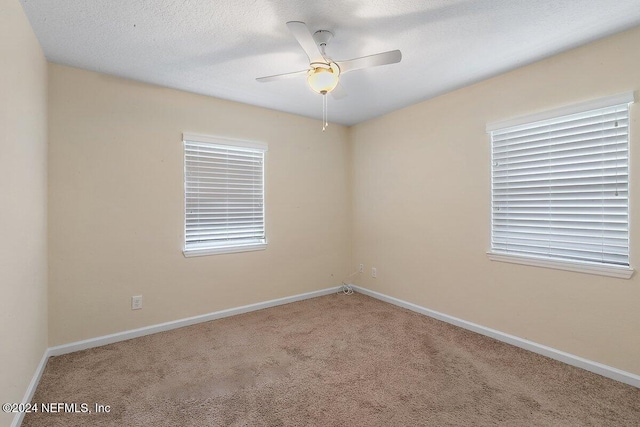 carpeted empty room with a textured ceiling and ceiling fan