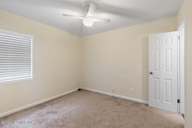 unfurnished room with a textured ceiling, light colored carpet, and ceiling fan