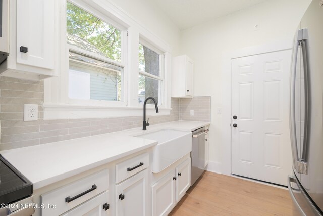 kitchen featuring white cabinetry, sink, stainless steel appliances, and light wood-type flooring