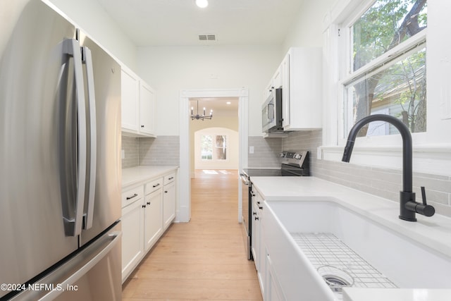 kitchen with white cabinets, a healthy amount of sunlight, and appliances with stainless steel finishes