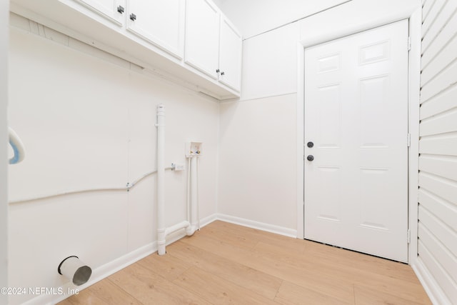 washroom featuring electric dryer hookup, washer hookup, cabinets, and light hardwood / wood-style floors