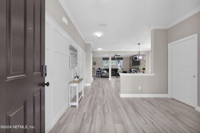 foyer with crown molding and light hardwood / wood-style flooring