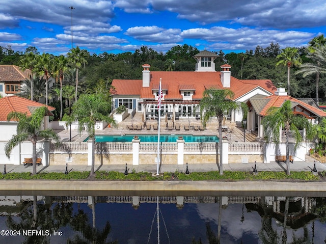 back of house featuring a water view and a patio area