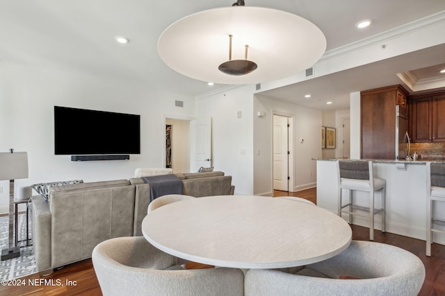 dining area with dark hardwood / wood-style floors and crown molding