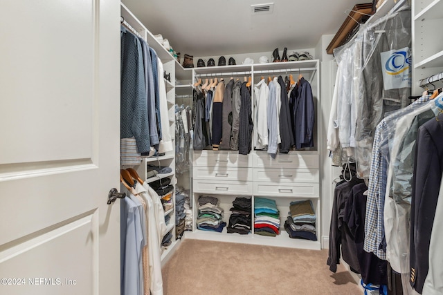 walk in closet featuring light colored carpet