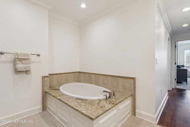 bathroom with tile patterned flooring, a bath, and ornamental molding