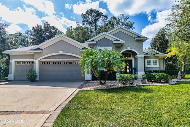 1854 W Cobblestone Ln, Saint Augustine, FL 32092 - view of front of home featuring stucco siding, a front yard, an attached garage, and driveway
