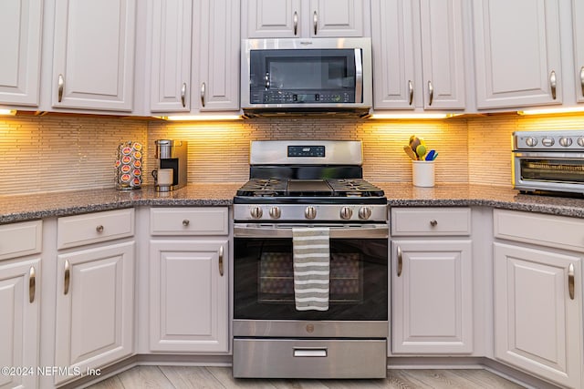 1854 W Cobblestone Ln, Saint Augustine, FL 32092 - kitchen with appliances with stainless steel finishes, white cabinetry, and backsplash