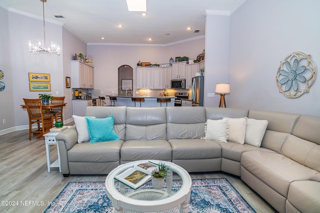 1854 W Cobblestone Ln, Saint Augustine, FL 32092 - living room featuring a chandelier, light wood finished floors, recessed lighting, crown molding, and baseboards