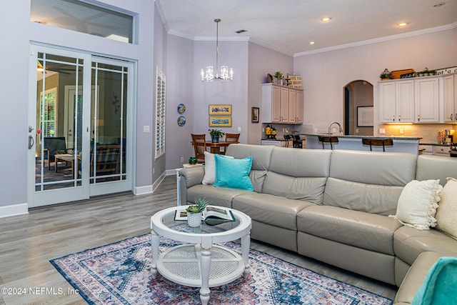 1854 W Cobblestone Ln, Saint Augustine, FL 32092 - living area with a chandelier, arched walkways, crown molding, baseboards, and light wood-type flooring