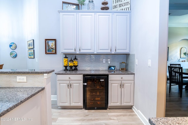 1854 W Cobblestone Ln, Saint Augustine, FL 32092 - indoor wet bar with beverage cooler, tasteful backsplash, light wood-type flooring, and baseboards