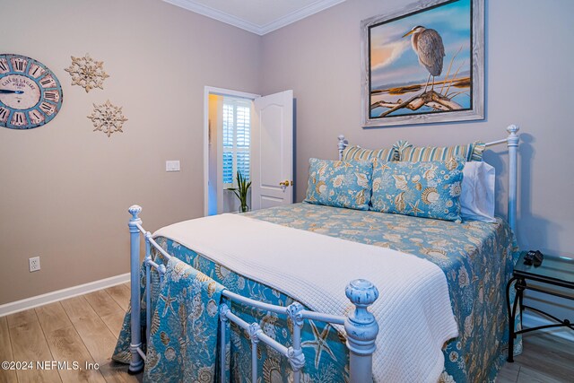 bedroom with hardwood / wood-style floors and crown molding