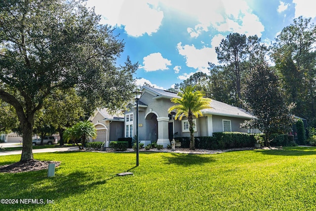 1854 W Cobblestone Ln, Saint Augustine, FL 32092 - view of front of home with a garage, stucco siding, and a front lawn