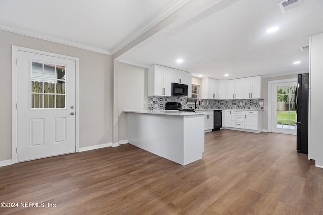 kitchen featuring black appliances, kitchen peninsula, white cabinetry, and hardwood / wood-style floors