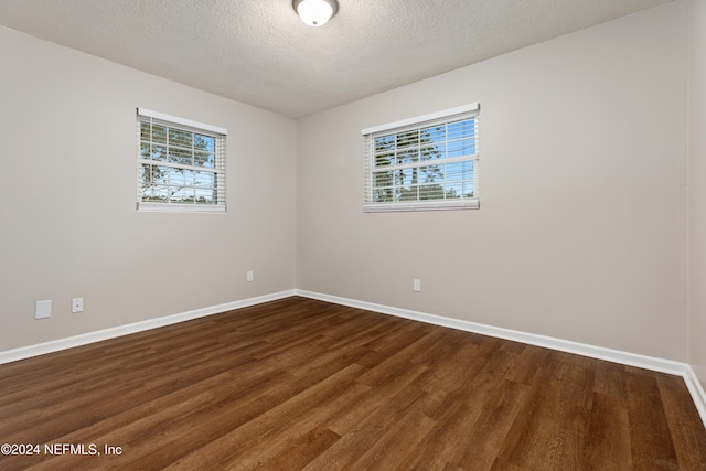 unfurnished room with hardwood / wood-style floors and a textured ceiling