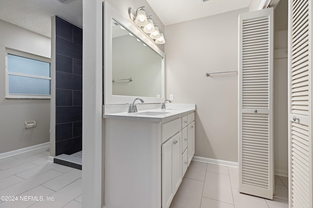 bathroom featuring tile patterned floors, vanity, and a shower