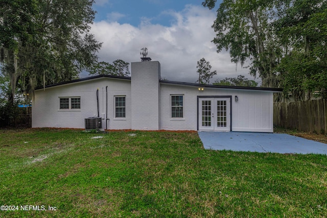 back of property featuring central AC unit, a patio area, a yard, and french doors