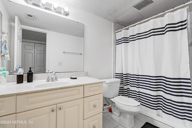 bathroom featuring toilet, vanity, a textured ceiling, and tile patterned floors