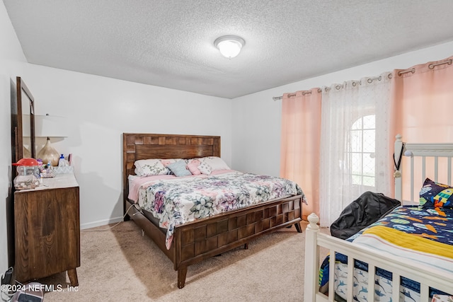 carpeted bedroom featuring a textured ceiling