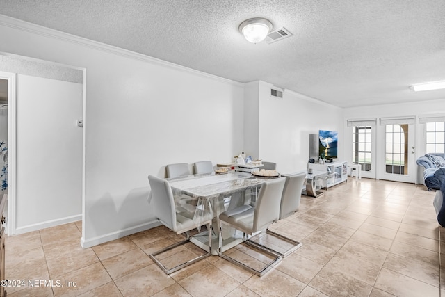 dining space with crown molding, light tile patterned flooring, and a textured ceiling