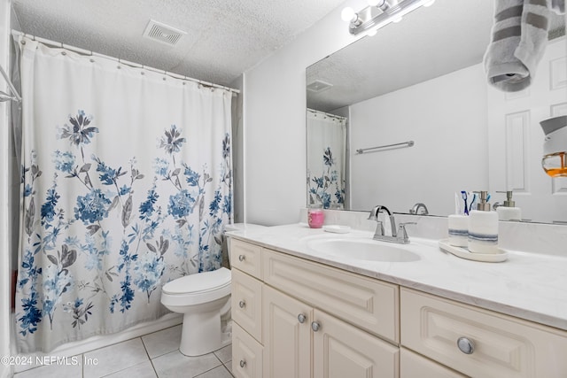 bathroom featuring a shower with shower curtain, tile patterned floors, vanity, a textured ceiling, and toilet