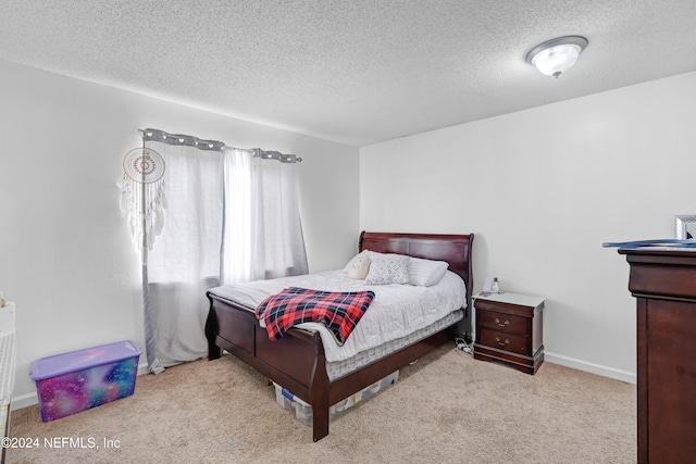 bedroom featuring a textured ceiling and light carpet