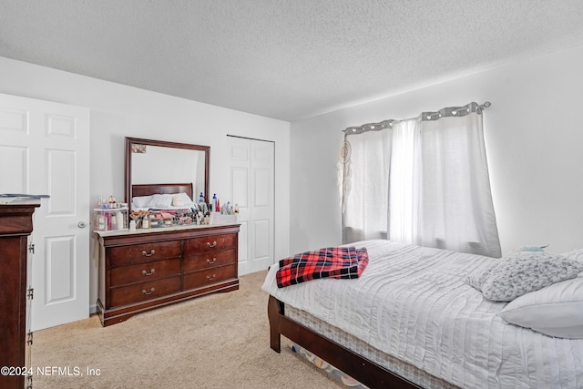 bedroom featuring a textured ceiling, light carpet, and a closet