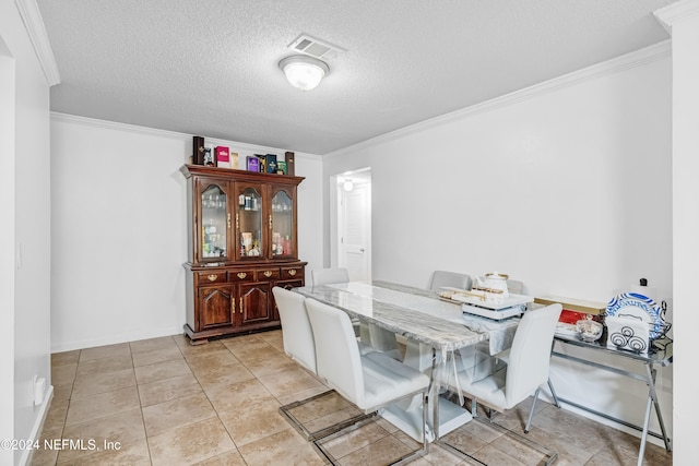 dining area featuring light tile patterned floors, a textured ceiling, and ornamental molding