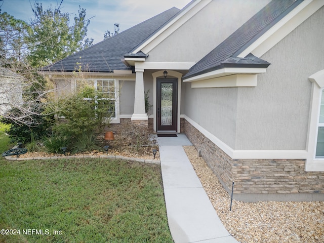 property entrance featuring a lawn