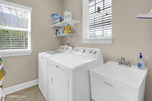 washroom featuring washing machine and dryer, sink, and light tile patterned floors