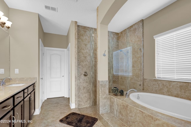 bathroom featuring plus walk in shower, tile patterned flooring, vanity, and a healthy amount of sunlight