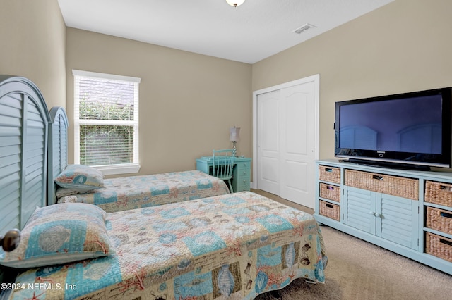 bedroom with light carpet and a closet